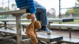 niño triste solo peluche
