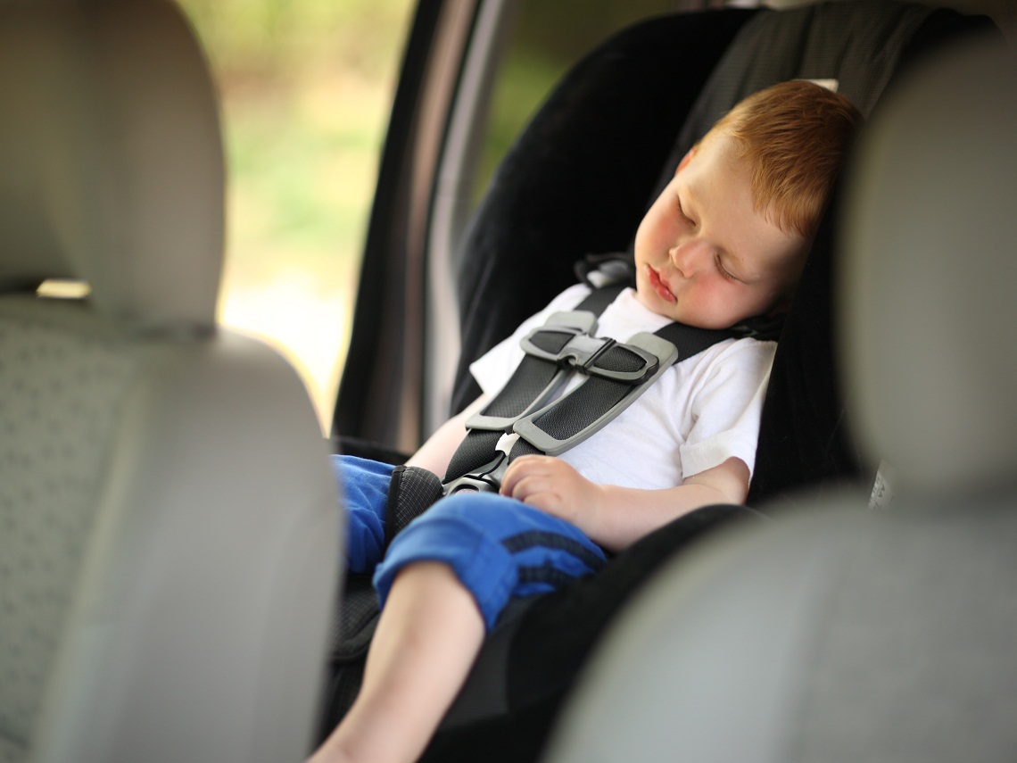 Niño durmiendo en el coche