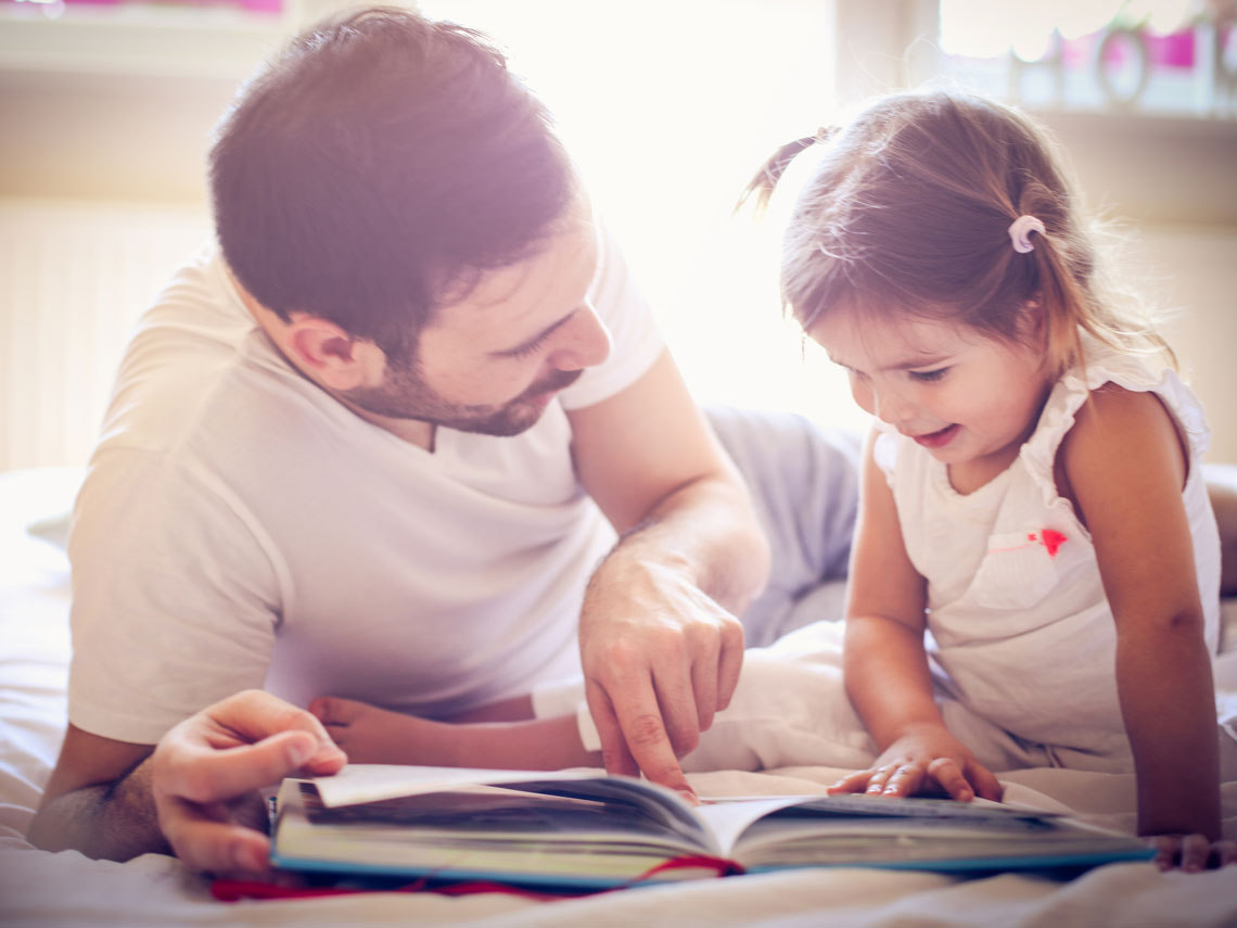 niña y padre leyendo un cuento