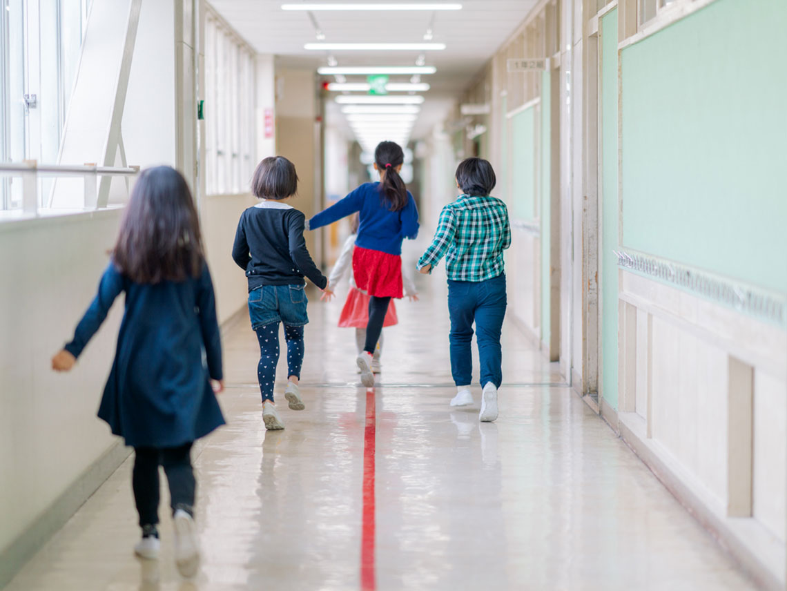 niños y niñas andando por el pasillo del colegio