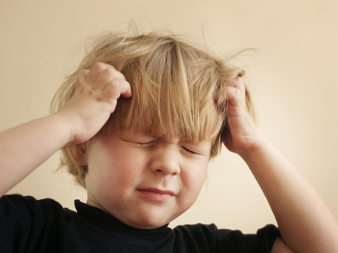 niño quejándose de dolor de cabeza