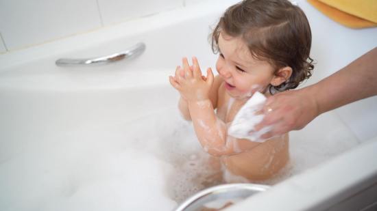 Mamá bañando a su hija con la esponja Babybaño