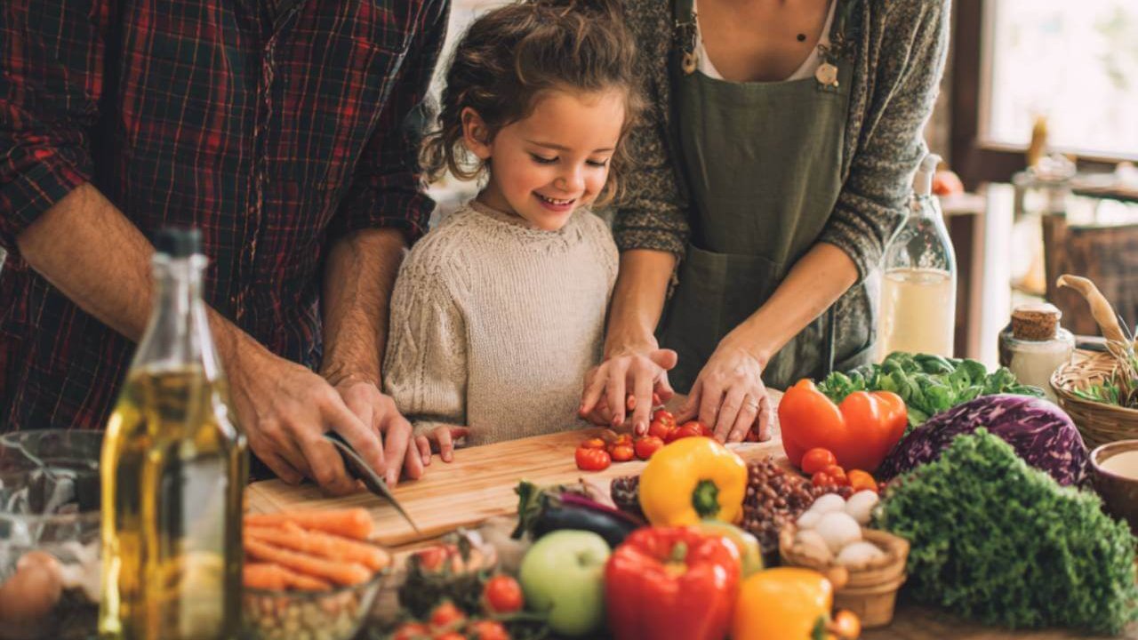 familia preparando comida saludable con verduras frescas en la cocina