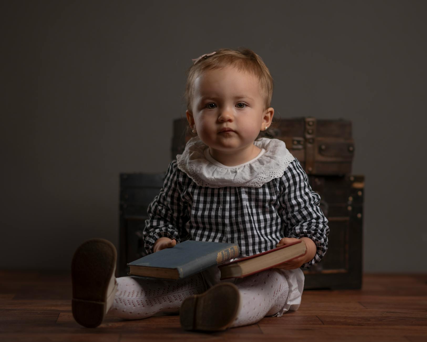 adorable baby sitting indoors with books