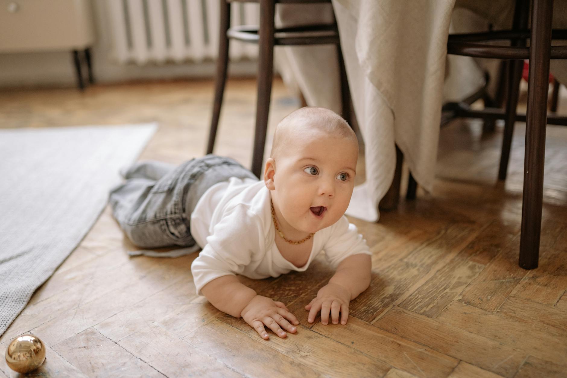 a baby crawling on wooden floor