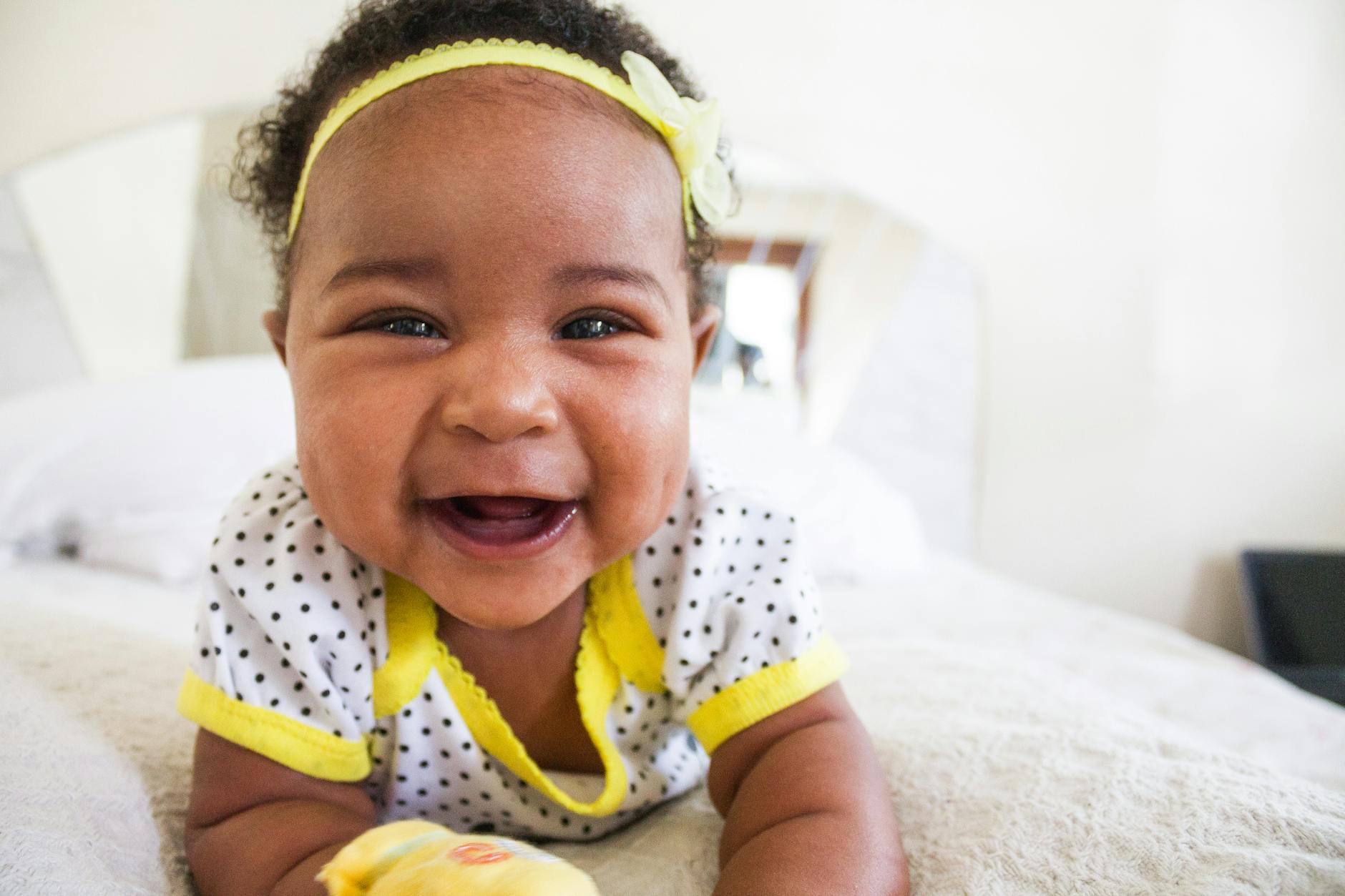 baby wearing white and yellow shirt