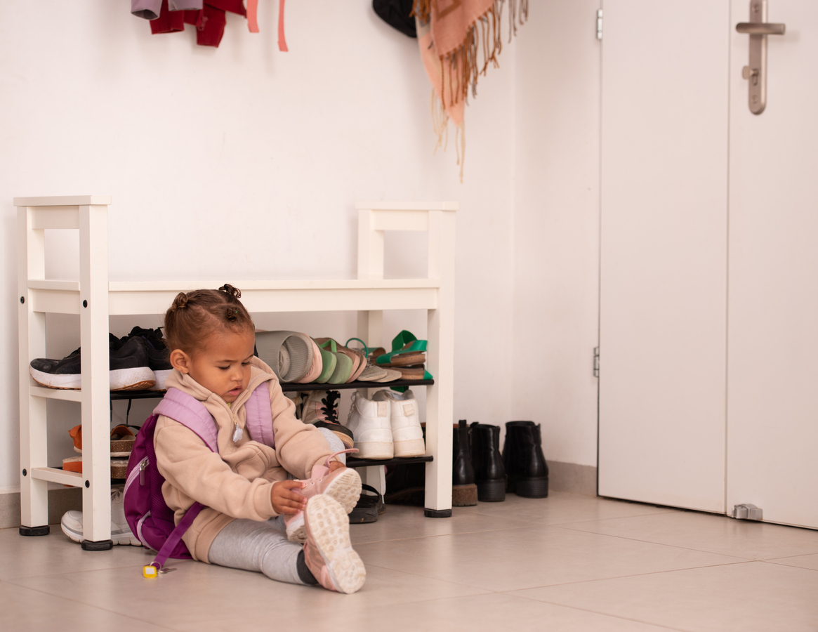 Niña poniéndose los zapatos