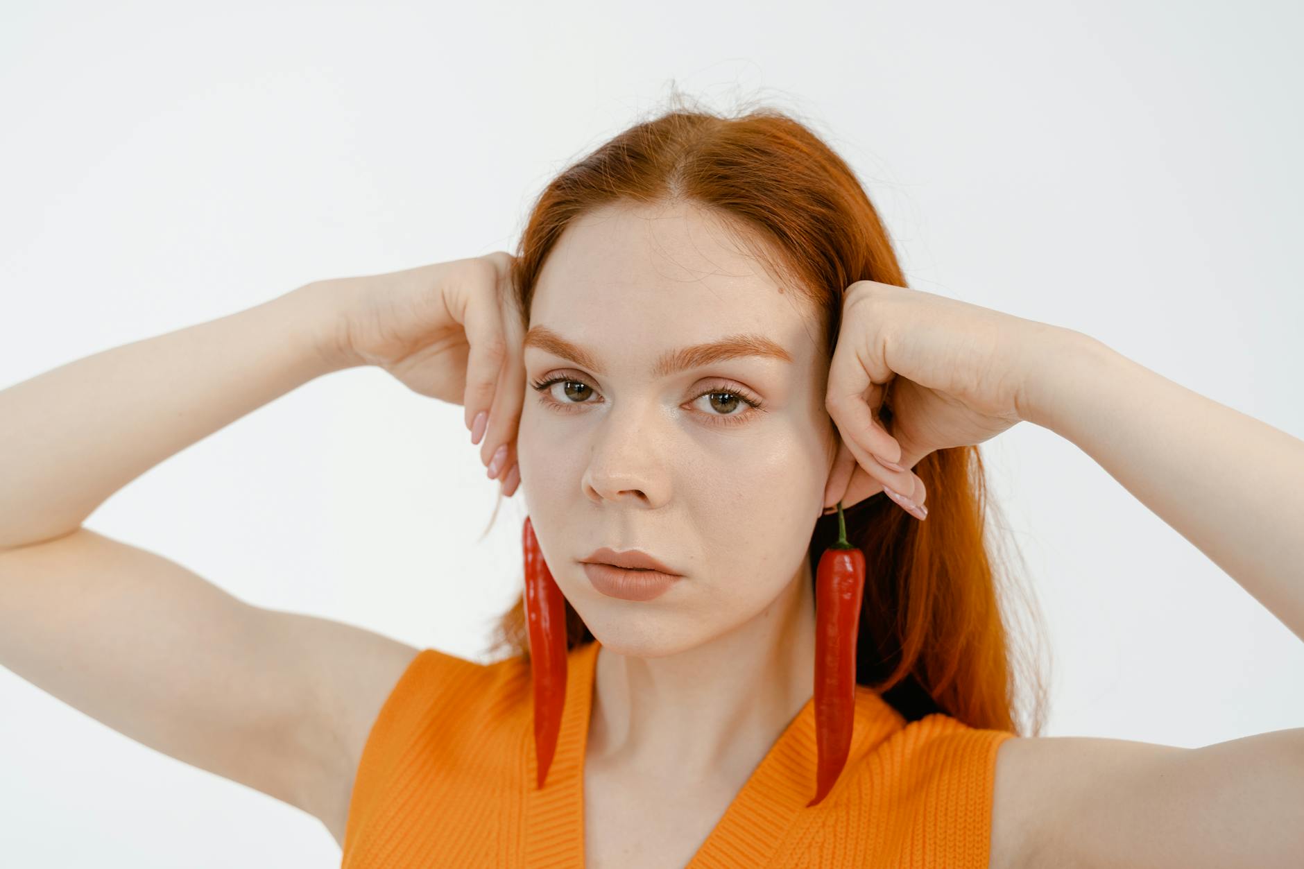 a woman holding red chili peppers as dangling