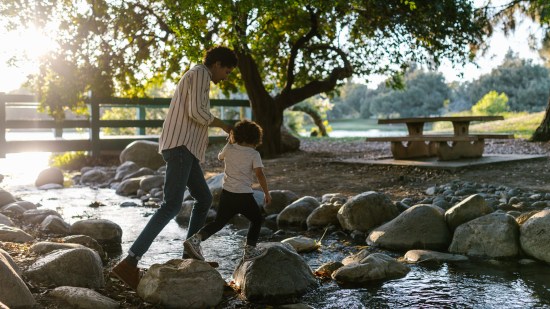 Padre e hijo cruzando un río