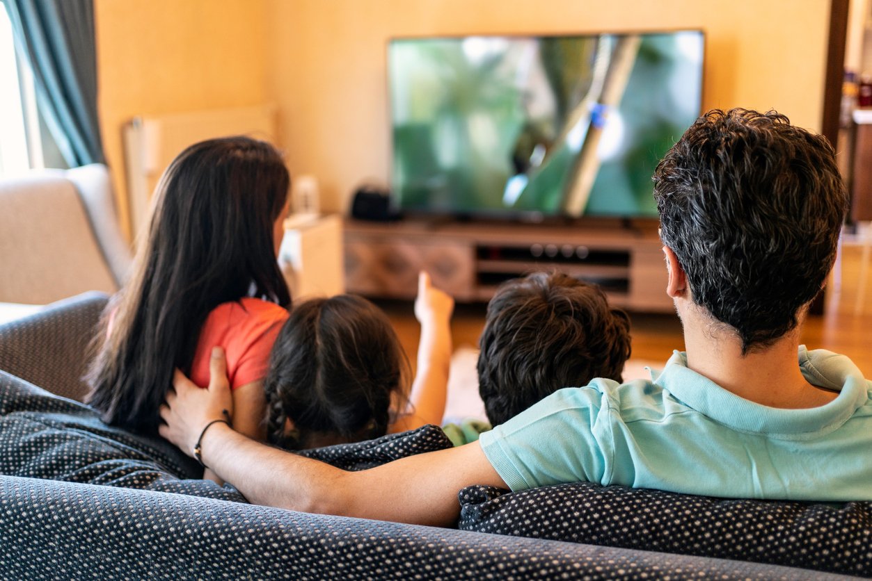 Padres viendo una película con sus hijos