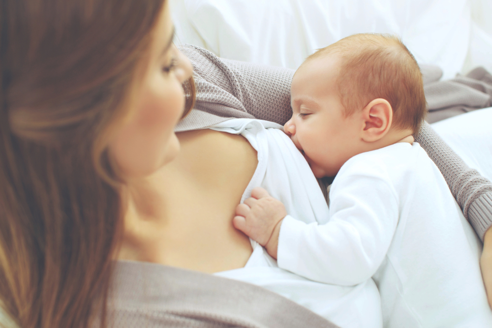 Mujer dando de comer a su hijo