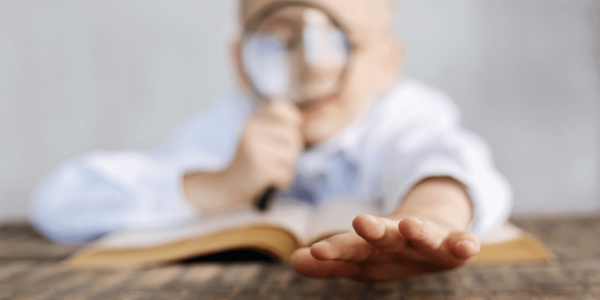 Niño con lupa leyendo
