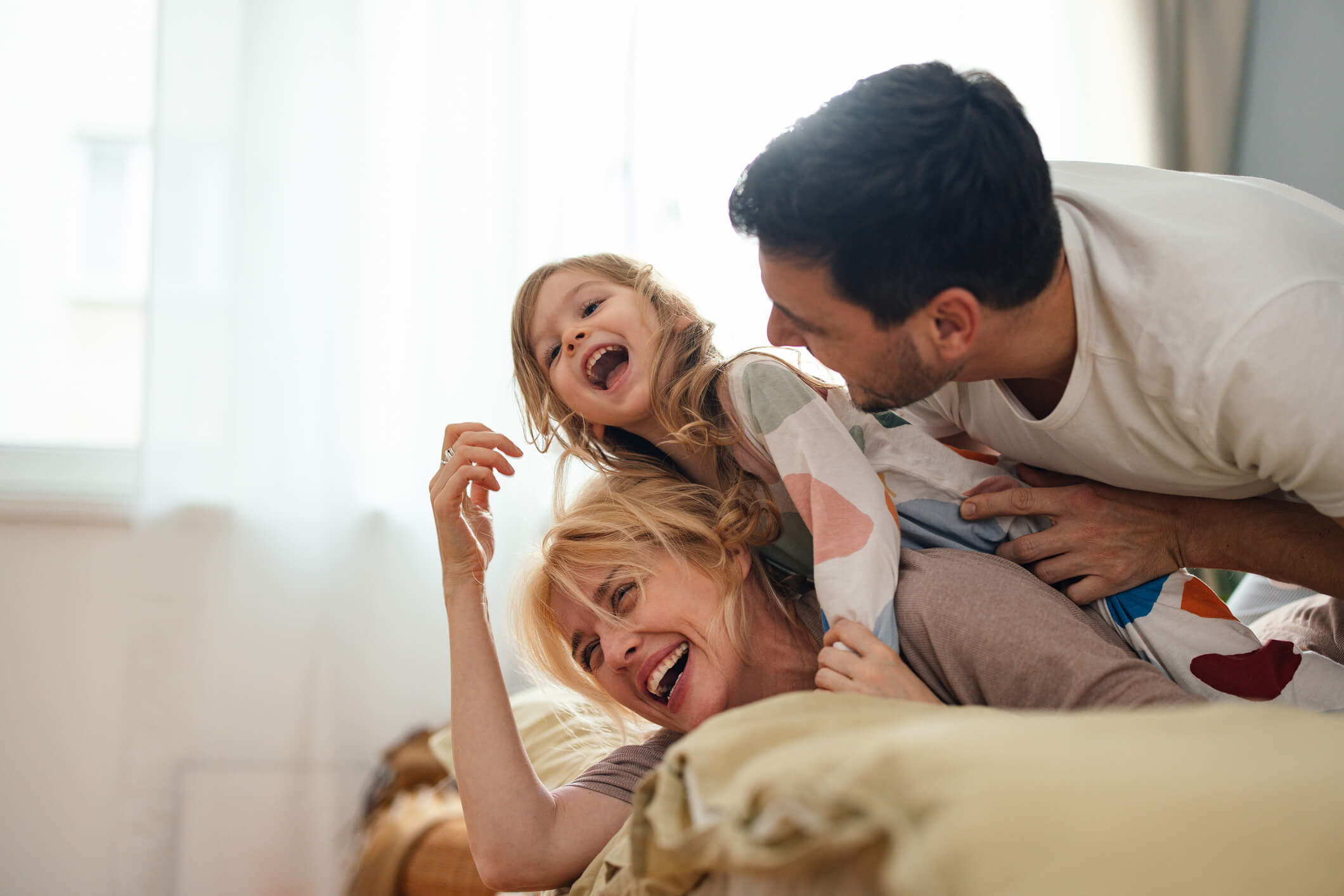 Familia divirtiéndose en la cama