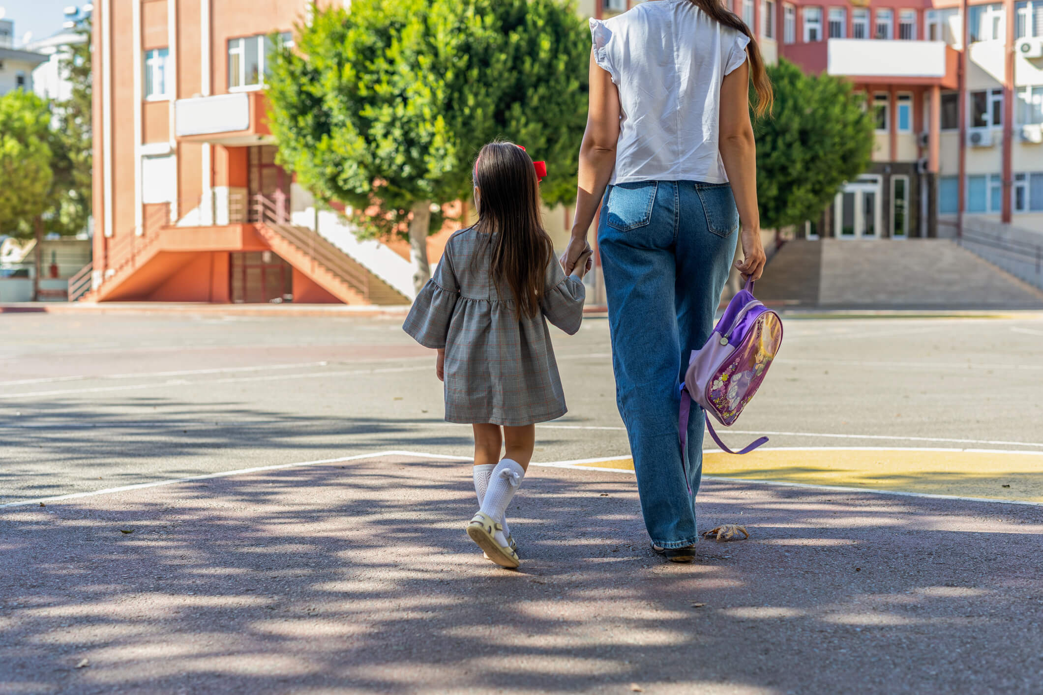 Niña y madre yendo a la escuela