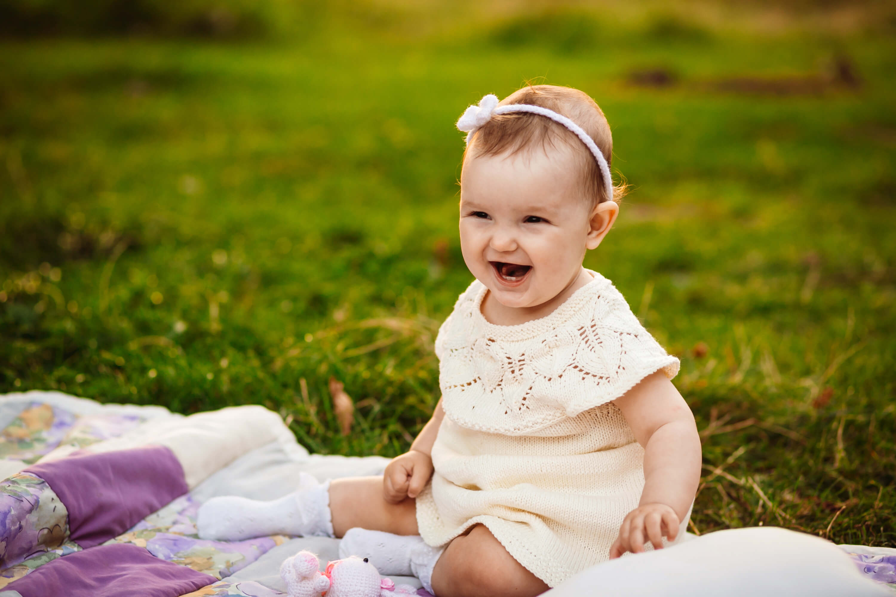 plump-little-girl-sits-white-blanket