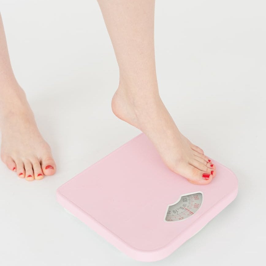 woman getting on scales in studio