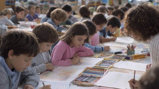 Niños y niñas de Primaria dibujando y coloreando en una clase de Educación Artística con su profesora.