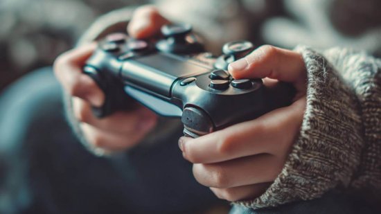 Manos de un niño con jersey sujetando un mando de videojuegos en primer plano, ilustrando el uso infantil de consolas y plataformas como Roblox.