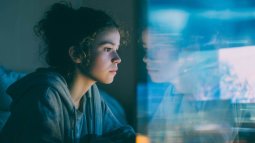 Adolescente frente a dos pantallas: una activa y otra pasiva, símbolo del impacto distinto del uso digital en el cerebro.