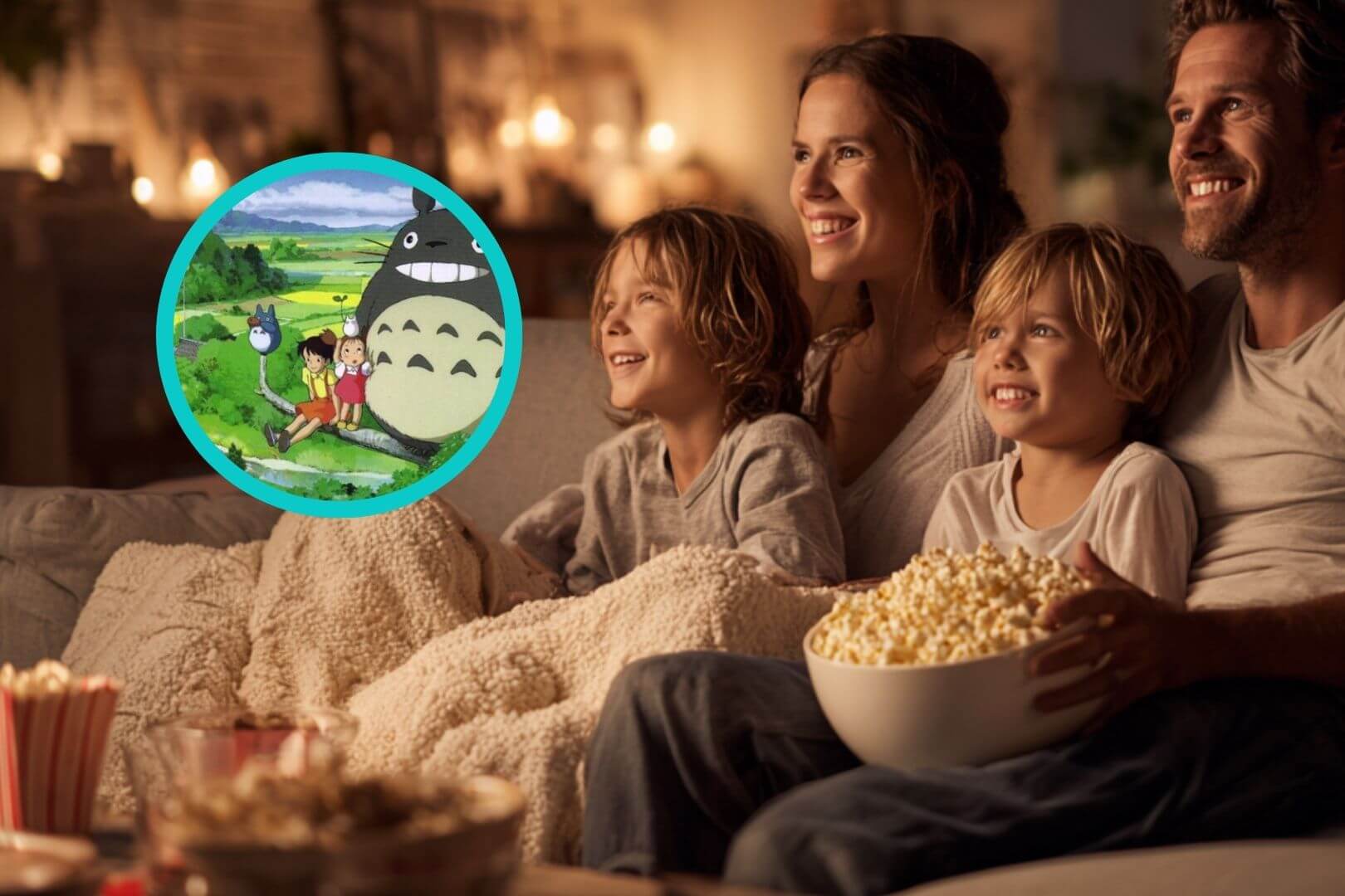 Familia sentada en el sofá con mantas y palomitas viendo juntos una película de Studio Ghibli en un ambiente cálido y acogedor.